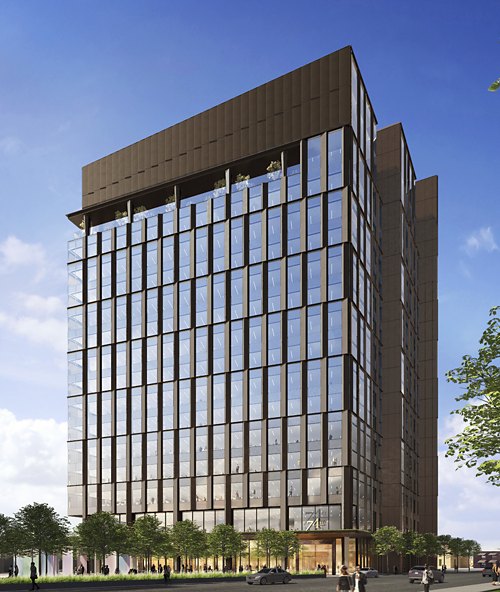 A modern high-rise building with a reflective glass façade and rooftop greenery stands under a clear blue sky. People stroll by its welcoming ground-level entrance lined with trees, indicating a lively urban setting.
